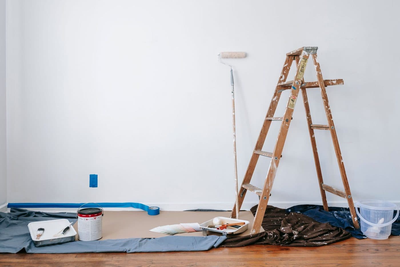 Pots de peinture alignés avec un mètre ruban pour calculer la quantité nécessaire