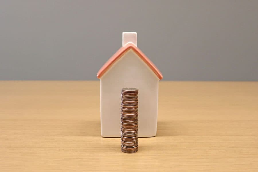 Maquette de maison et pièces de monnaie