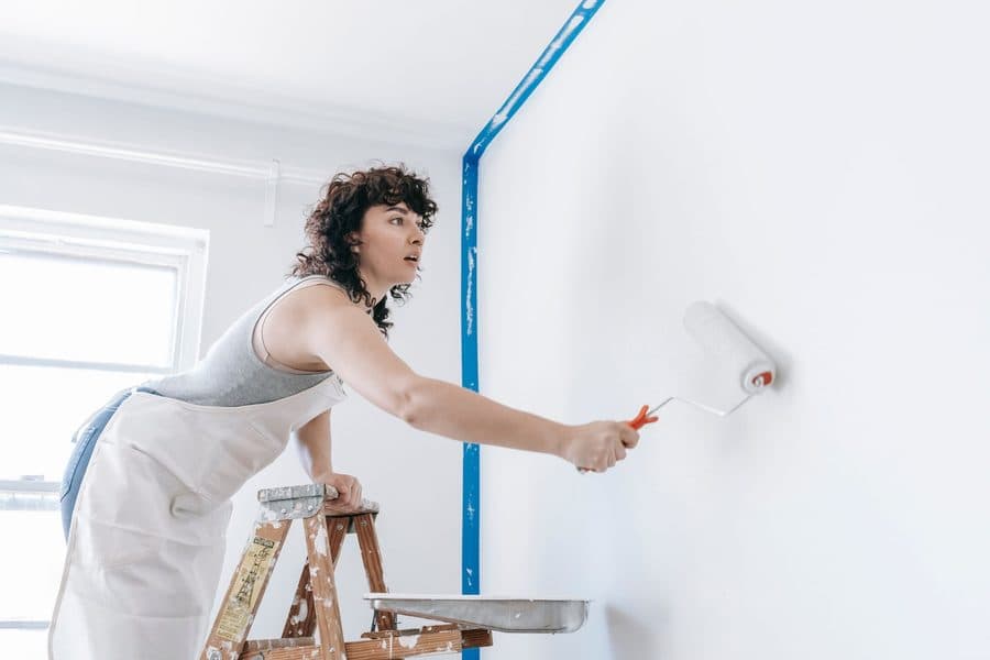 Peintre appliquant une couche au rouleau